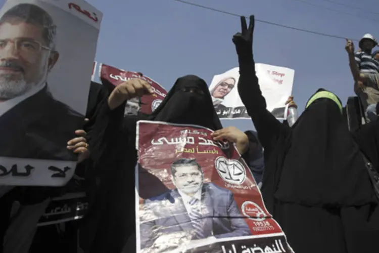 Membros da Irmandade Muçulmana e defensores do presidente egípcio deposto Mohamed Mursi exibem pôsteres em manifestações em resposta a pedido de comandante do Exército (Amr Abdallah Dalsh/Reuters)