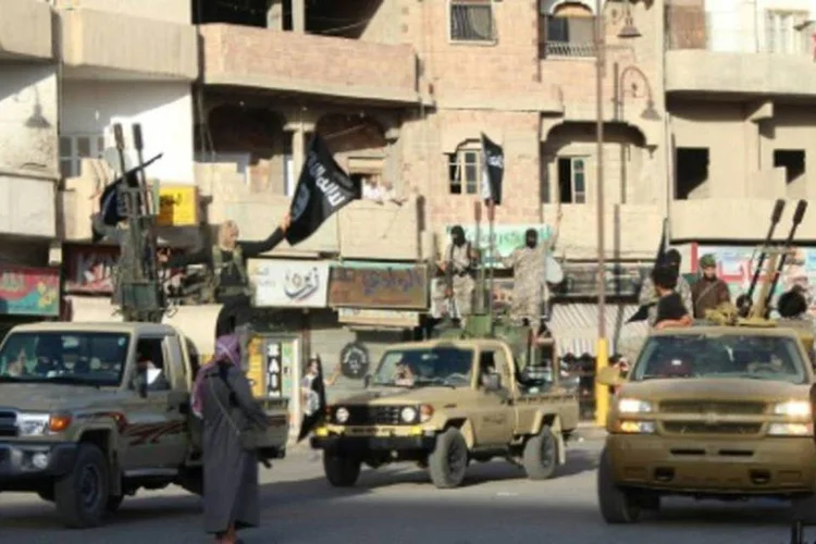 
	Extremistas do grupo EI s&atilde;o vistos em Raqa, S&iacute;ria: segundo a coaliz&atilde;o, dois ataques pr&oacute;ximos do basti&atilde;o dos militantes em Raqqa destru&iacute;ram tr&ecirc;s escavadeiras e uma unidade t&aacute;tica
 (WELAYAT RAQA/AFP)