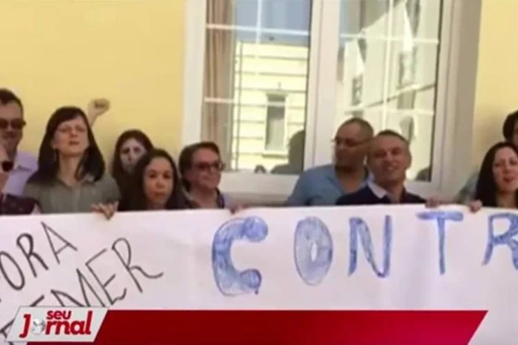 
	Ela Wiecko (&agrave; esq, segurando a faixa, de &oacute;culos escuros): um v&iacute;deo que circula na internet mostra Ela em protesto que aconteceu em junho deste ano, em Portugal contra o impeachment
 (Reprodução/Rede TVT)
