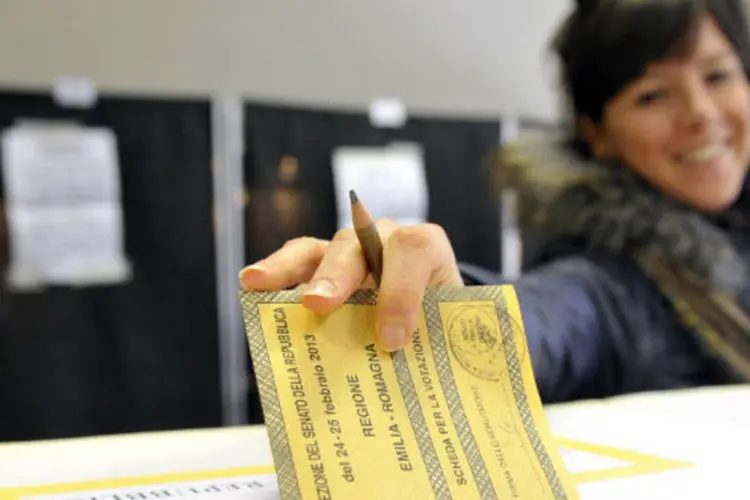 Eleitora italiana deposita seu voto na assembleia de Piacenza, na Itália (REUTERS / Paolo Bona)