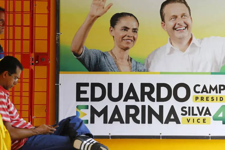 Membros do PSB aparecem ao lado de cartaz da campanha de Eduardo Campos à Presidência (Ricardo Moraes/Reuters)