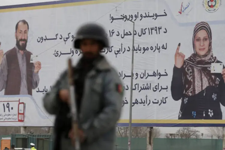 Um outdoor instalado perto de um posto de controle exibe propaganda das eleições presidenciais, em Cabul, no Afeganistão (Mohammad Ismail/Reuters)