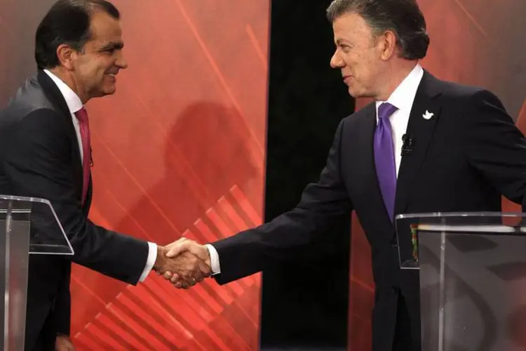 Juan Manuel Santos cumprimenta Oscar Ivan Zaluaga durante um debate televisivo em Bogotá (John Vizcaino/Reuters)