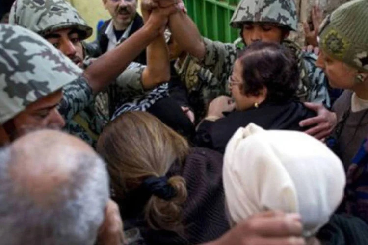 Soldados tentam organizar entrada de eleitores em centro de votação no Cairo: as longas filas quase não se movimentam em alguns dos centros eleitorais ao longo desta manhã


 (Odd Andersen/AFP)