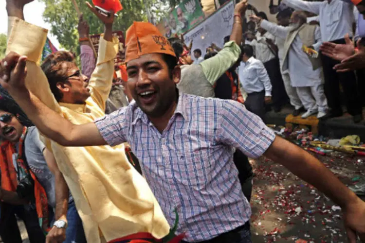 Apoiadores do partido indiano Bharatiya Janata (BJP) celebram após resultado das eleições em Nova Déli (Adnan Abidi/Reuters)
