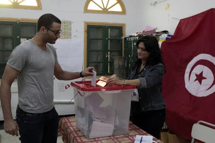 
	Tunisiano deposita o seu voto: o pa&iacute;s &eacute; tido como exemplo de mudan&ccedil;a democr&aacute;tica na regi&atilde;o que ainda luta para lidar com o rescaldo das revoltas da chamada Primavera &Aacute;rabe em 2011
 (Anis Mili/Reuters)