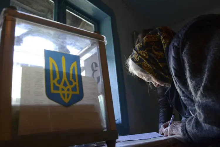 Ucraniana preenche uma cédula de votação durante as eleições parlamentares, na vila de Fiina, próximo de Lviv (Roman Baluk/Reuters)