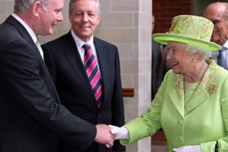 Elizabeth II cumprimenta Martin McGuinness em Belfast: ele passou de dirigente do IRA a líder no processo de paz que resultou no acordo de 1998 (Paul Faith/AFP)