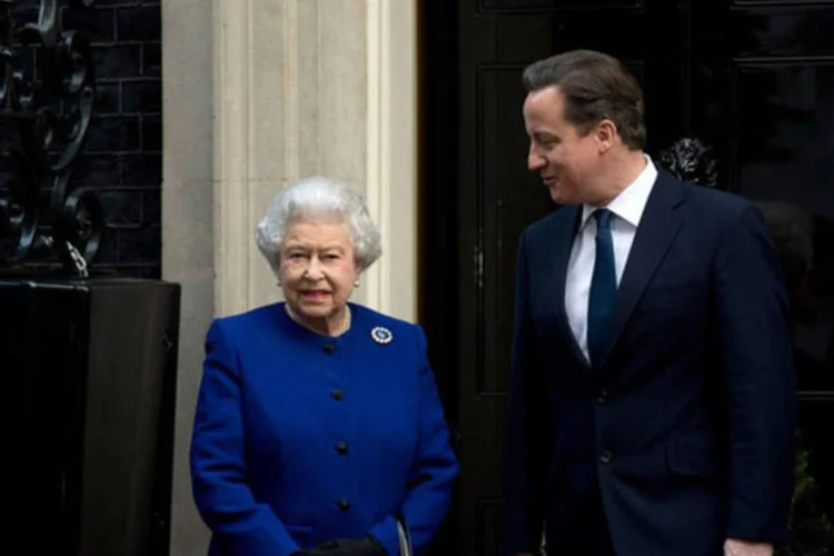 
	Cameron e a rainha brit&acirc;nica: como aponta o protocolo, o premi&ecirc; foi &agrave; resid&ecirc;ncia real para uma audi&ecirc;ncia pessoal com Elizabeth II
 (Adrian Dennis/AFP)