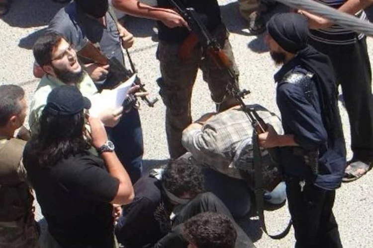 Rebeldes se preparam para matar dois homens supostamente indiciados por uma corte islâmica, na província síria de Idlib (Amr Radwan Al-Homsi/AFP)