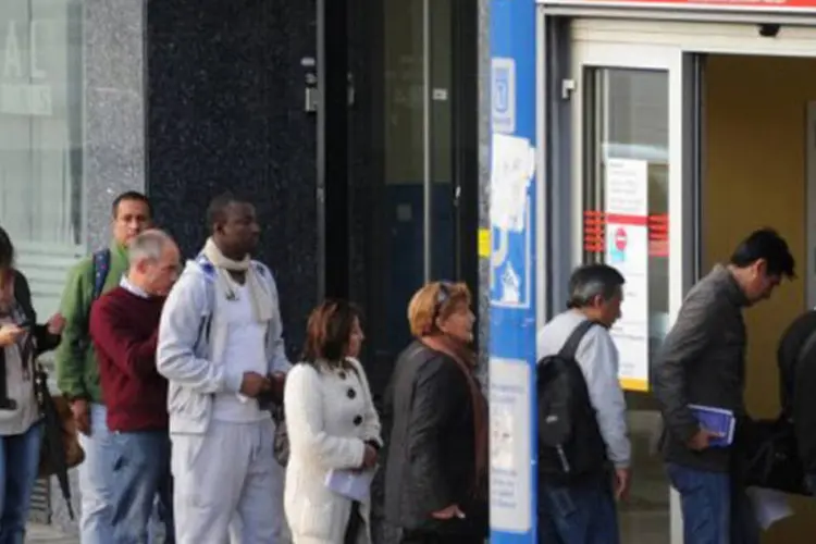 
	Espanh&oacute;is aguardam na fila de um escrit&oacute;rio de empregos em Madri: o n&uacute;mero de pessoas que solicitaram aux&iacute;lio-desemprego recuou para 4.698.783, uma queda de 31 pessoas
 (Dominique Faget/AFP)