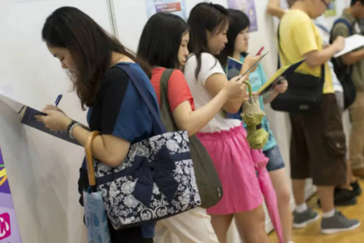 Chineses preenchem formulários em feira de empregos de Hong Kong (Jerome Favre/Bloomberg)