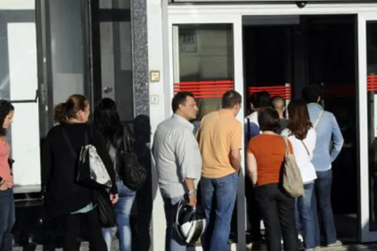 
	Pessoas em frente &agrave; ag&ecirc;ncia de emprego na Espanha: agora j&aacute; h&aacute; 4.907.817 desocupados no pa&iacute;s
 (Dominique Faget/AFP)