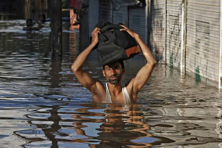 Homem anda por lugar alagado em Srinagar: mais de 1,5 milhão foram afetados (Adnan Abidi/Reuters)