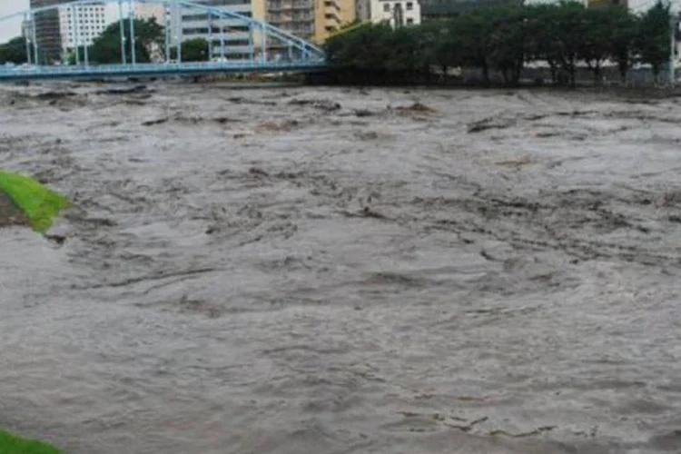 As enchentes tomam conta de um rio na cidade de Kumamoto na ilha de Kyushu, do sul do Japão, na quinta-feira (Jiji Press/AFP)