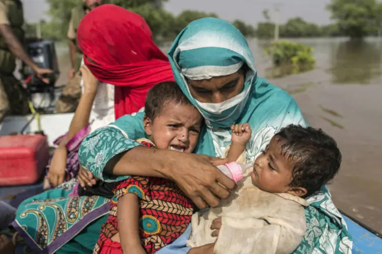 
	V&iacute;tima da enchente em Punjab, no Paquist&atilde;o, alimenta beb&ecirc; com garrafa enquanto eles s&atilde;o evacuados em barco por soldados do ex&eacute;rcito
 (Zohra Bensemra/Reuters)