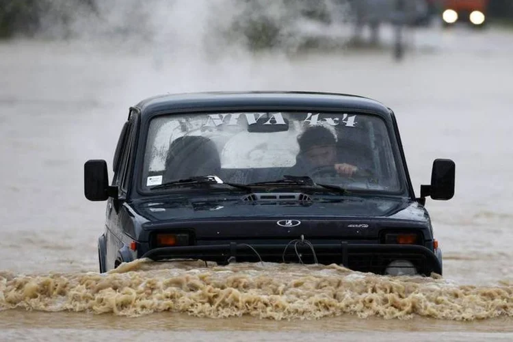 Homem guia o seu carro em uma rua alagada na cidade de Lazarevac, ao sul de Belgrado, na Sérvia (Marko Djurica/Reuters)