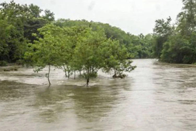 Rio transborda após chuvas em Bayamo, Cuba, enquanto moradores se preparam para a chegada do furacão em 24 de outubro
 (AFP)
