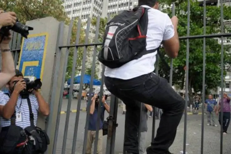 
	Encena&ccedil;&atilde;o: candidato Vitor Gomes chega &quot;atrasado&quot; e tenta pular port&atilde;o para fazer o Enem na Uerj
 (Fernando Frazão/Agência Brasil)