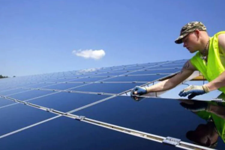 Técnico instala paineis fotovoltaicos para a captura de energia solar, na França (.)