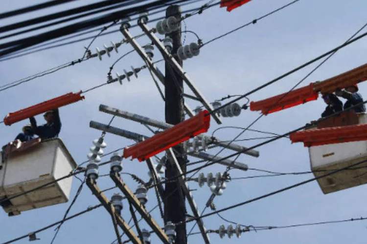 
	Trabalhadores consertam poste de energia el&eacute;trica: no acumulado do ano, a Light, que atua em gera&ccedil;&atilde;o e distribui&ccedil;&atilde;o de energia el&eacute;trica, tinha queda de cerca de 31%
 (REUTERS/Erik De Castro)