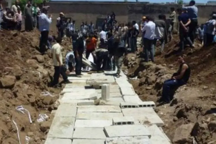 Enterro coletivo no dia 26 de maio de vítimas do massacre de Houla (Shaam News Network/AFP)
