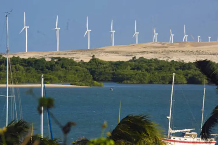 Energia eólica, ao fundo, e catamarã na foz do Rio Jaguaribe, no Ceará. (LUIS MORAIS)
