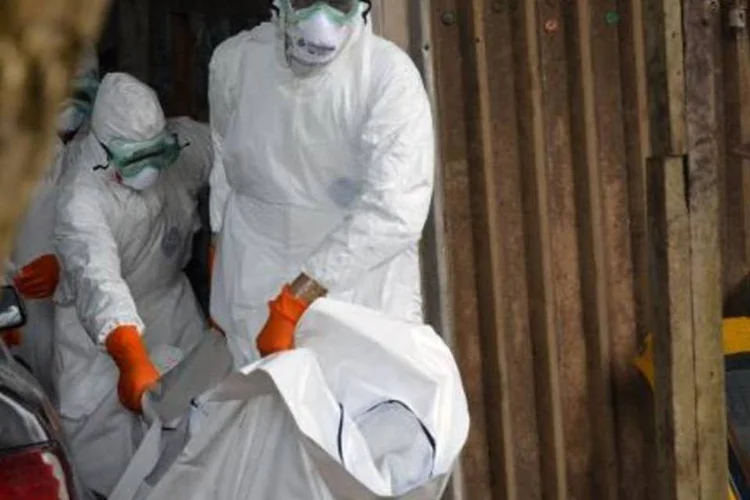 
	Funcion&aacute;rios da Cruz Vermelha liberiana transportam corpo de v&iacute;tima de ebola
 (Zoom Dosso/AFP)