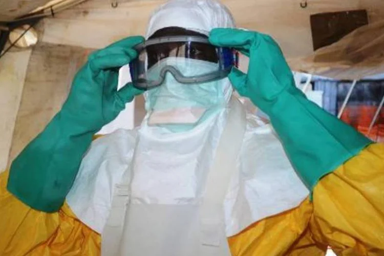 
	Membro da ONG M&eacute;dicos Sem Fronteiras coloca roupa especial para entrar em &aacute;rea de isolamento de um hospital de Conacri, Guin&eacute;
 (Cellou Binani/AFP)