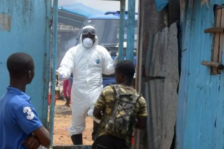 Parentes de pessoas infectadas pelo vírus Ebola aguardam notícias na entrada de uma zona de risco do hospital John Kennedy, em Monróvia, na Libéria (Dominique Faget/AFP)