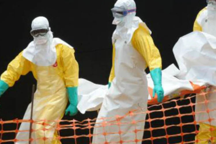 Equipe da ONG Médicos sem Fronteiras remove o corpo de uma vítima de febre hemorrágica, na Guiné: ebola já deixou mais de 80 mortos no país (AFP)