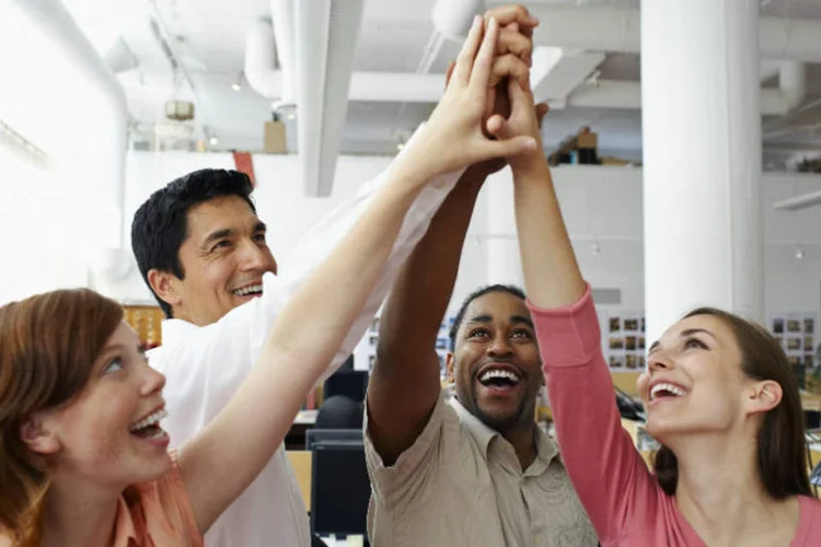 Trabalho em equipe (funcionários juntam as mãos) (Thinkstock)