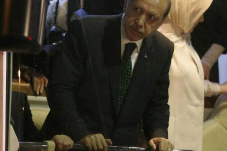 Turkey's Prime Minister Tayyip Erdogan (C) looks at supporters after arriving at Istanbul's Ataturk airport early June 7, 2013. Erdogan called on Turks on Friday to distance themselves from lawless protests and said accusations of the excessive use of police force during days of unrest were being investigated. Addressing thousands of supporters at Istanbul airport after returning from a trip to North Africa, Erdogan said the protesters had looted shops and damaged businesses and urged his supporters not to be drawn into the violence. (TURKEY - Tags: CIVIL UNREST POLITICS) (REUTERS/Stoyan Nenov)
