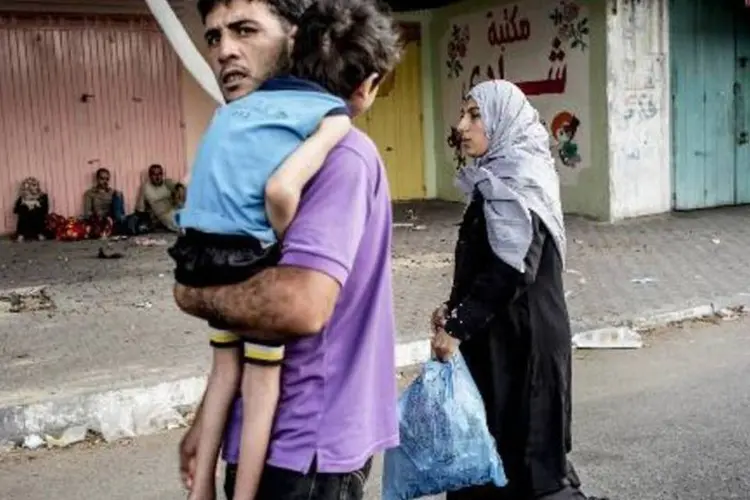  Homem caminha com a família até uma escola da ONU em Beit Lahia que recebe refugiados internos (Marco Longari/AFP)