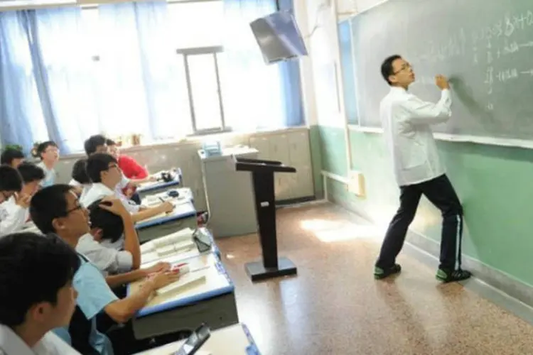 Aluno resolve problema matemático em sala de aula de Xangai, na China (AFP / Peter Parks)