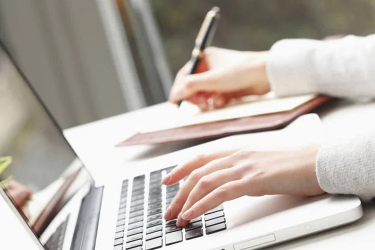 mulher escreve e digita (Thinkstock/Szepy)