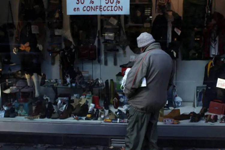 
	Homem olha para loja em distrito comercial de Madri: economia espanhola retraiu-se 1,3% em 2012 na compara&ccedil;&atilde;o anual
 (Susana Vera/Reuters)