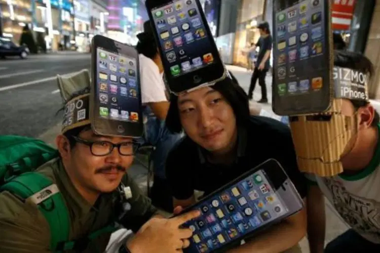 Fãs da Apple usam chapéus em homenagem ao iPhone 5 em Tóquio, no Japão (Toru Hanai/Reuters)