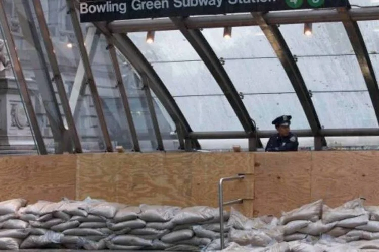 
	Policial de Nova York faz guarda na entrada do metro fechado no centro de Manhattan, amea&ccedil;ado pela tempestade Sandy
 (Andrew Kelly/Reuters)
