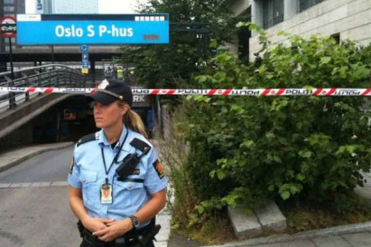 Uma policial isola a entrada de uma das estações de trem de Oslo: "parece-me normal que a polícia esteja atenta. Não estamos assustados" (AFP)