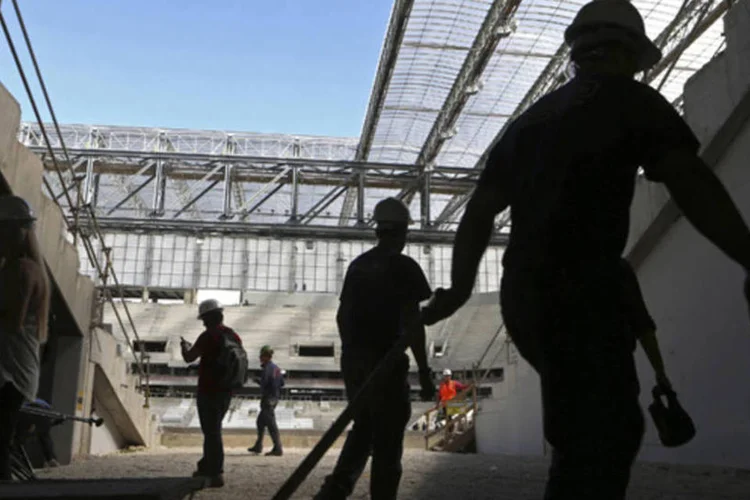 
	Trabalhadores dentro da Arena da Baixada: est&aacute;dio ainda est&aacute; em reforma para o Mundial de junho e correu o risco de ficar fora do torneio
 (Rodolfo Buhrer/Reuters)
