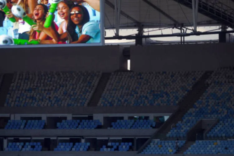 
	Torcedores aparecem em tel&atilde;o do est&aacute;dio do Maracan&atilde;: o Minist&eacute;rio do Turismo promete realizar 1,6 mil obras em cidades que est&atilde;o em torno do raio de 100 quil&ocirc;metros das cidades-sede da Copa
 (Dado Galdieri/Bloomberg)