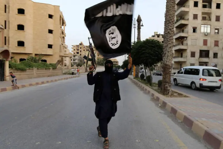 
	Homem com bandeira do Estado Isl&acirc;mico
 (Reuters)