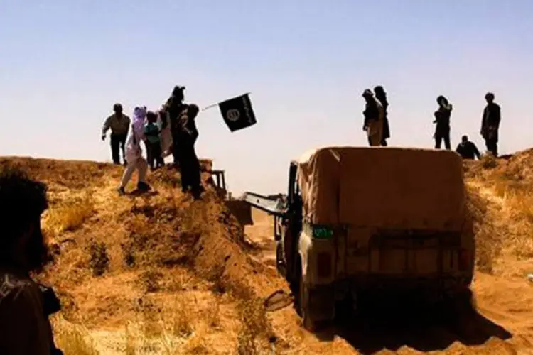 Imagem divulgada no Twitter pela conta Al-Baraka em 9 de junho mostra supostos militantes do EI em uma estrada entre o Iraque e Síria
 (AFP)