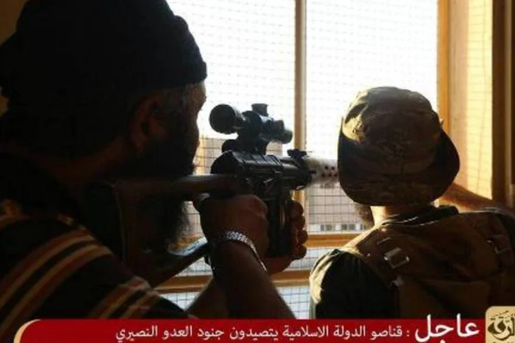 Imagem divulgada pela mídia jihadista Welayat Raqa mostra supostos membros do Estado Islâmico alvejando soldados sírios, em Raqa (AFP)