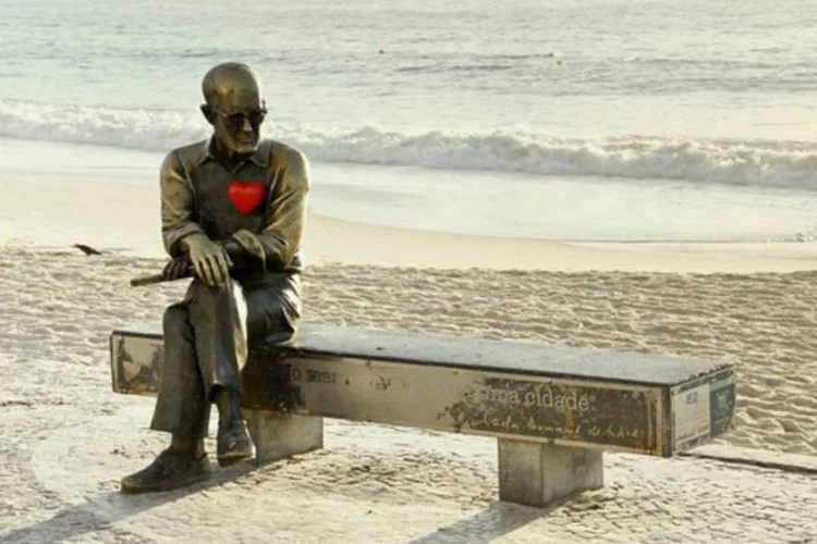 Estátua do poeta Carlos Drummond de Andrade, situada um banco na orla da praia de Copacabana, ganhou um coração (Aqui bate um coração/Facebook)