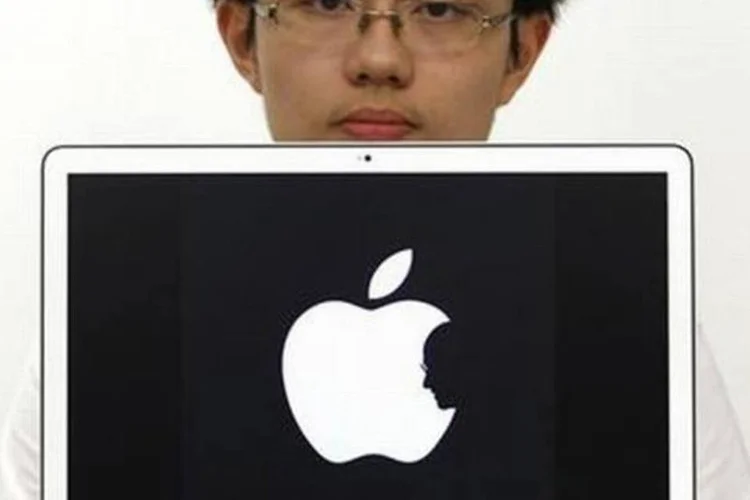 Estudante de Design de Hong Kong Jonathan Mak posa com o logo mofificado com a silhueta de Steve Jobs, em Hong Kong, na quinta-feira (Bobby Yip/Reuters)