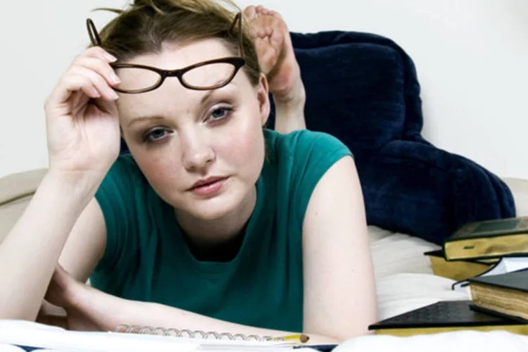 Estudante com livros e caderno (Dreamstime)