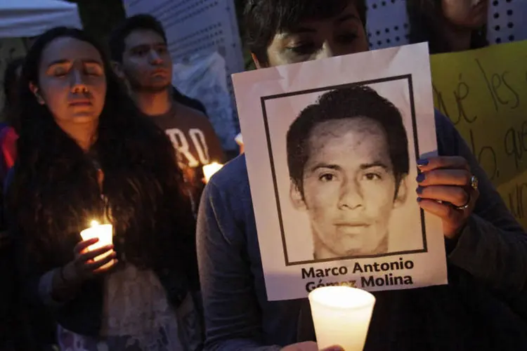 Estudantes seguram velas e fotografias dos estudantes desaparecidos, durante um protesto em Monterrey, no México (Daniel Becerril/Reuters)