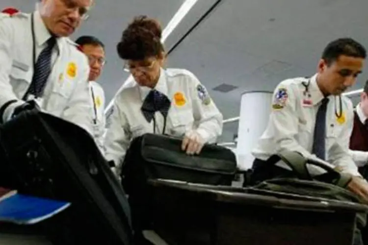 Inspetores da Administração de Segurança nos Transportes dos EUA (TSA) revistam bagagens no aeroporto internacional de San Francisco (AFP)